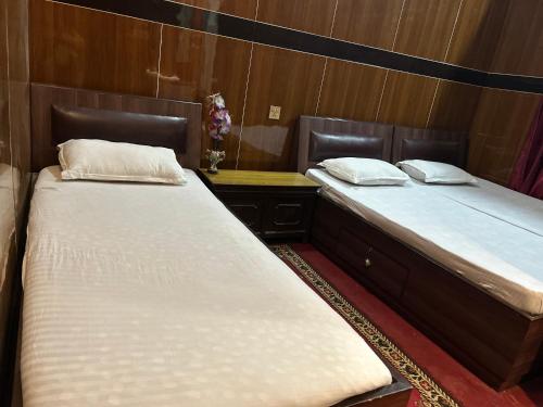 two twin beds in a room with a desk at Sudha’s Garden Home in Kathmandu