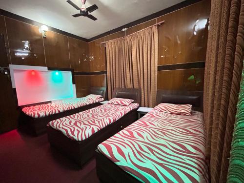 two beds in a room with a projection screen at Sudha’s Garden Home in Kathmandu
