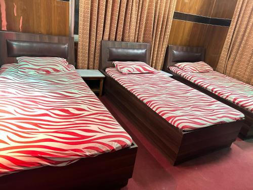 two beds sitting next to each other in a room at Sudha’s Garden Home in Kathmandu