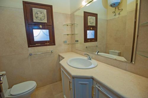 a bathroom with a sink and a toilet and a mirror at 4 Bed El Gouna Villa in Hurghada