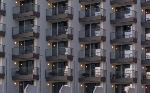 a facade of a building with balconies and chairs at Cádiz Bahía by QHotels in Cádiz