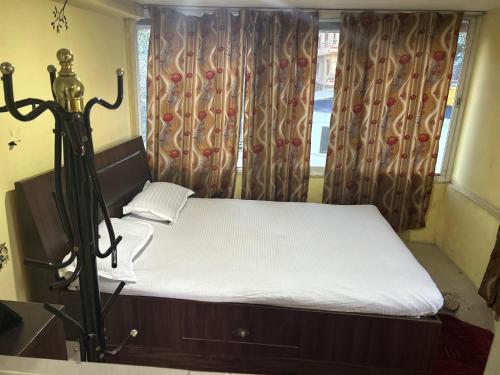 a bedroom with a bed and a window with curtains at Sudha’s Garden Home in Kathmandu