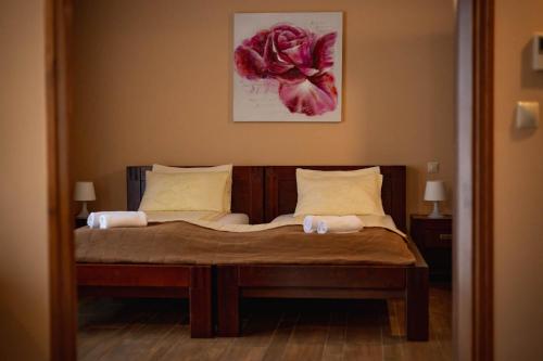 1 dormitorio con 1 cama con una flor roja en la pared en Maya Panzio, en Szeged