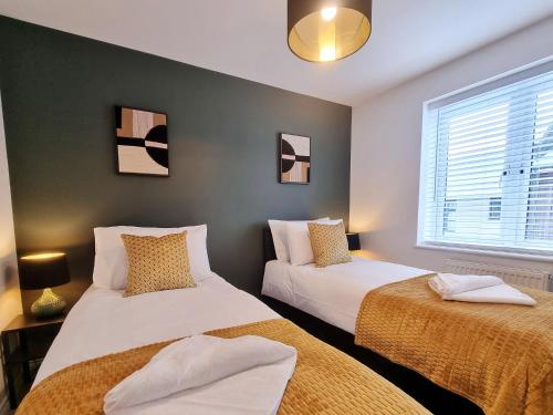 1 dormitorio con 2 camas y ventana en Modern & Spacious 3 bedrooms and 2 bathrooms Home, Free Parking!, en Cambridge