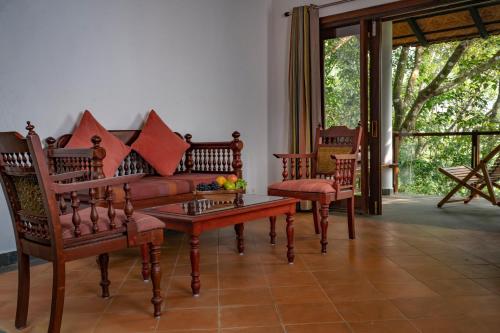 a living room with a couch and chairs and a table at Vythiri Mist Resort in Vythiri