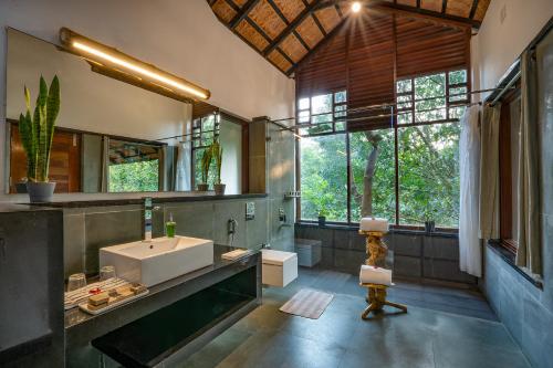 a bathroom with a large sink and a large mirror at Vythiri Mist Resort in Vythiri