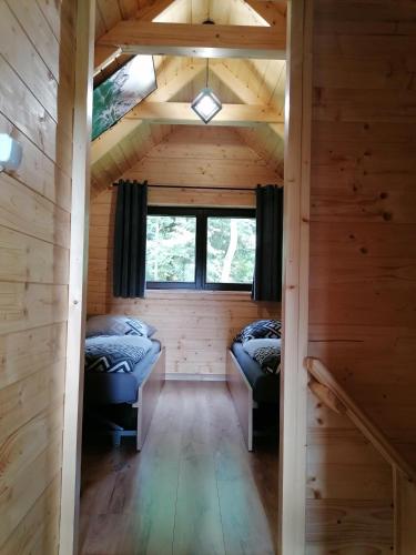 a room with two beds in a log cabin at Agroturystyka W oddali z balią in Międzylesie