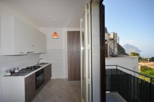 eine Küche mit weißen Geräten und einem Balkon in der Unterkunft Appartamenti da Clarissa in Macari