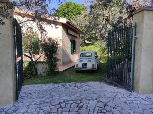 une petite voiture blanche garée devant une porte dans l'établissement Alloggio turistico Monte Santa Maria, à Poggio Nativo