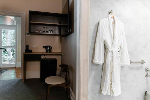 a white robe hanging on a wall in a bathroom at Oxford on Otho in Inverell