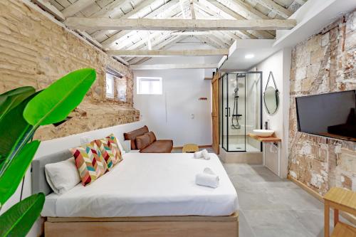 a bedroom with a white bed and a tv at Trinitarios Apartment in Toledo
