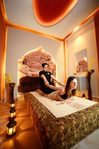 a man and a woman sitting on a bed at Pickalbatros Jungle Aqua Park - Neverland Hurghada in Hurghada