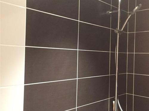 a bathroom with a shower with black tiles at Appartement Mont-Dore, 3 pièces, 4 personnes - FR-1-415-77 in Le Mont-Dore