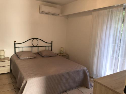 une chambre avec un grand lit et une fenêtre dans l'établissement Appartement 2P avec Balcon, Clim, à 50m de la Plage et Centre-ville, WiFi et Parking Disponibles - FR-1-466A-3, à Saint-Raphaël