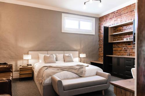 a bedroom with a bed and a chair in it at Oxford on Otho in Inverell