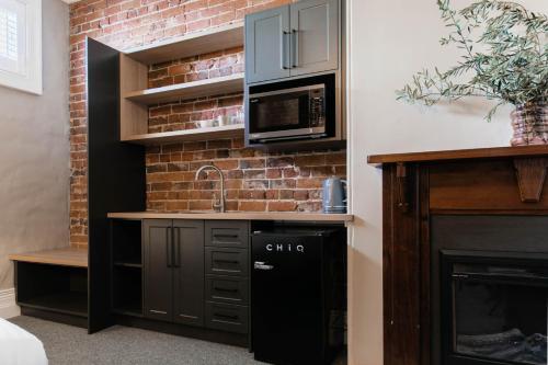 a kitchen with a microwave and a fireplace at Oxford on Otho in Inverell