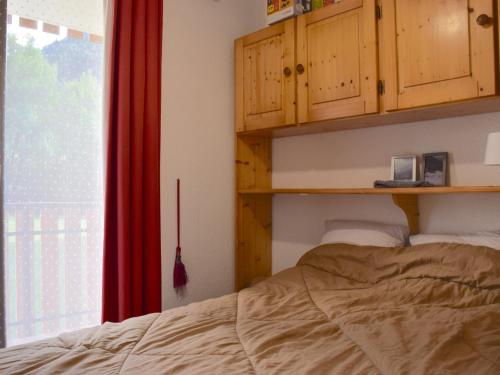 a bedroom with a bed and wooden cabinets and a window at Appartement Bernex, 2 pièces, 6 personnes - FR-1-498-50 in Bernex