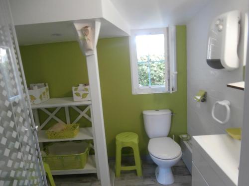 La salle de bains est pourvue de toilettes et d'un mur vert. dans l'établissement Appartement Capbreton, 4 pièces, 8 personnes - FR-1-239-484, à Capbreton