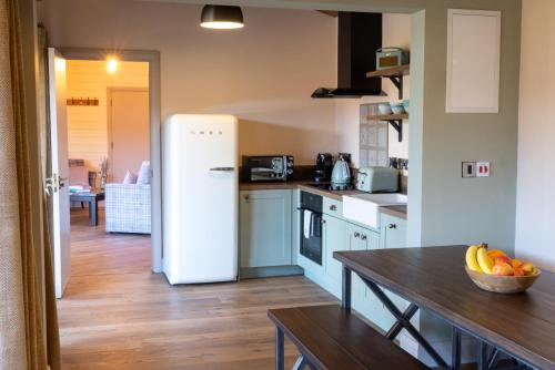 a kitchen with a table and a white refrigerator at Wildlands Galway in Moycullen