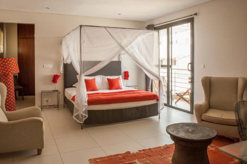 a bedroom with a canopy bed and a balcony at La Villa 126 Dakar in Dakar
