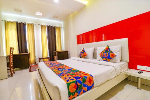 a bedroom with a large bed with a red headboard at FabHotel Golden Home in Amritsar