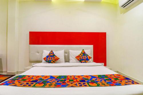 een slaapkamer met een groot bed met een rood hoofdeinde bij FabHotel Golden Home in Amritsar