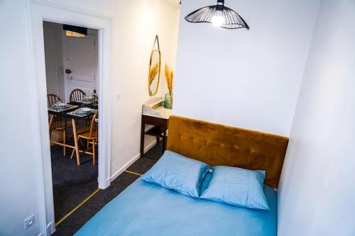 a bedroom with a blue bed and a dining room at Le Petit Marin • Cosy • Netflix & Wifi • Proche Centre-Ville in Châteauroux