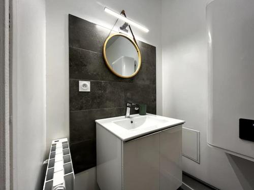 a bathroom with a white sink and a mirror at Le Petit Marin • Cosy • Netflix & Wifi • Proche Centre-Ville in Châteauroux