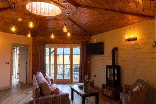a living room with couches and a flat screen tv at Wildlands Galway in Moycullen