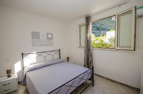 a bedroom with a bed and a window at Appartamenti da Clarissa in Macari