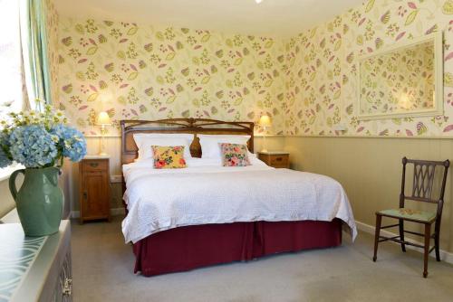 a bedroom with a bed and a vase of flowers at Admiral's Cottage in Bridport