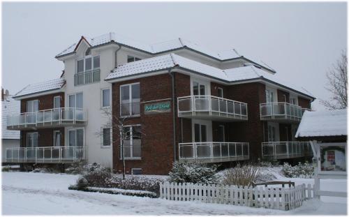 a large brick building with snow on top of it at Ferienwohnungen Auf der Düne in Cuxhaven