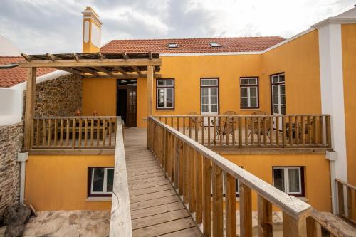 a wooden stairway leading to a yellow building with a church at Villa Galega in Santa Cruz