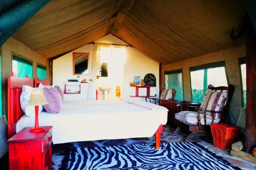 a bedroom with a bed and a piano in a room at Omukuyu Wildlife Lodge in Otavi