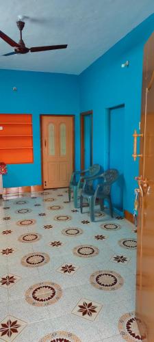 a room with blue walls and a table and chairs at MURALI VILLAS in Yelagiri