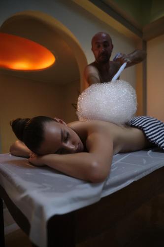 a woman laying on a bed in front of a man at Eressian Hotel & Hammam Spa in Eresos