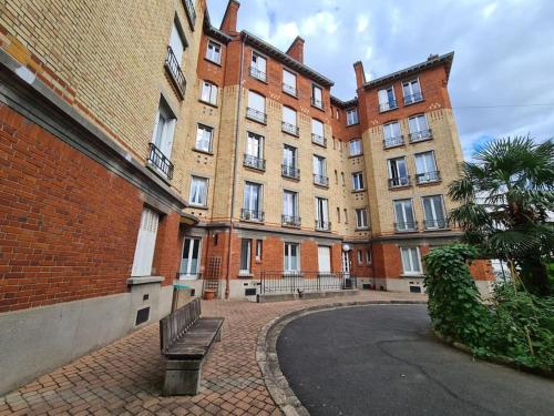 a large brick building with a bench in front of it at Suresnes : 2 pièces cosy in Suresnes