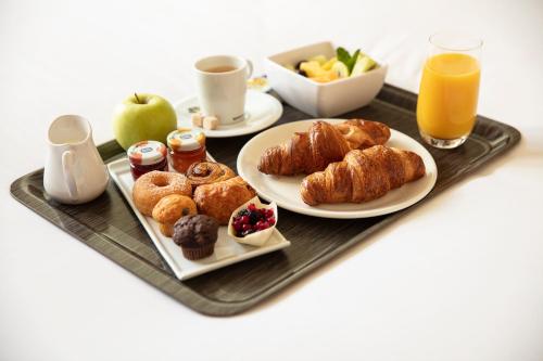a tray with two plates of pastries and orange juice at Boutique Apartments Amsterdam in Amsterdam