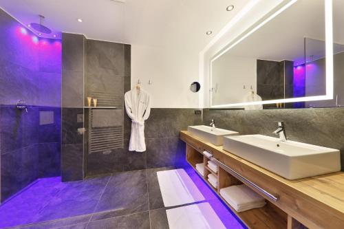 シェーナにあるHotel Panoramaのバスルーム(洗面台2台、鏡付)