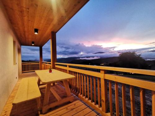 a wooden balcony with a table and a view of the ocean at Ritschhof in Castelrotto