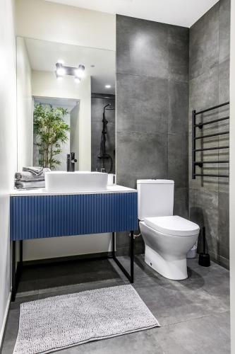 a bathroom with a tub and a toilet and a sink at Botanical Garden Loft in Kaunas