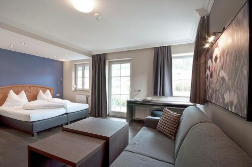 ein Hotelzimmer mit einem Bett und einem Sofa in der Unterkunft HAIDVOGL MAVIDA Zell am See in Zell am See