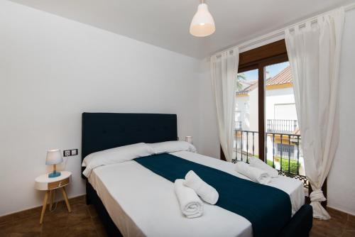 een slaapkamer met een groot bed en een raam bij Peace & Golf - Mijas Duplex Apartment- Pets Friendly in Fuengirola
