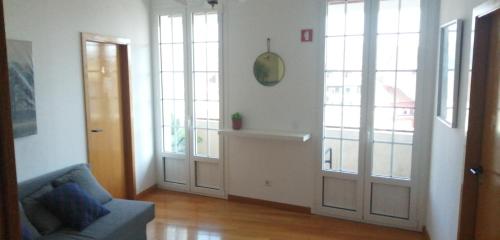 a living room with two doors and a couch at Guest House Sir Manuel - Unidade Senhora A Branca in Braga