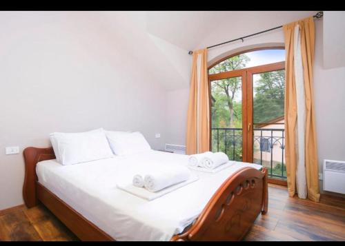 a bedroom with a bed with two towels on it at Dilijan Dream House! 3 Bedroom Amazing Villa in National Park! in Dilijan