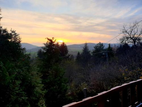 a view of the sunset from a hill with trees at Égig Érő Fa Vendégház in Nógrád