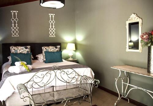 a bedroom with a bed and a chair and a mirror at Kroon Manor in Kroonstad