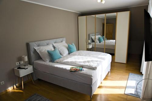 um quarto com uma cama com almofadas azuis e um espelho em Moselchalet em Piesport