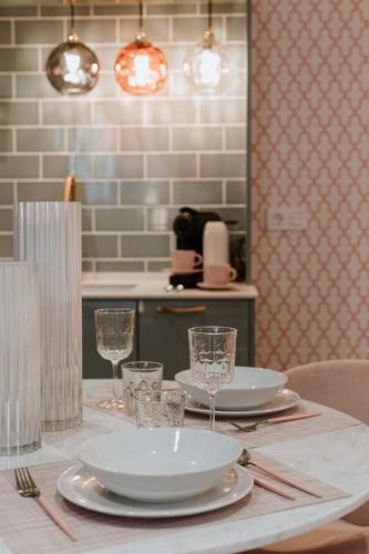 a table with plates and glasses on top of it at Apartamentos Boutique Heritage in San Martín de Trevejo