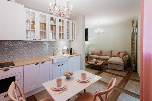 Una cocina y una sala de estar con una mesa y un sofá. en Apartamentos Boutique Heritage, en San Martín de Trevejo